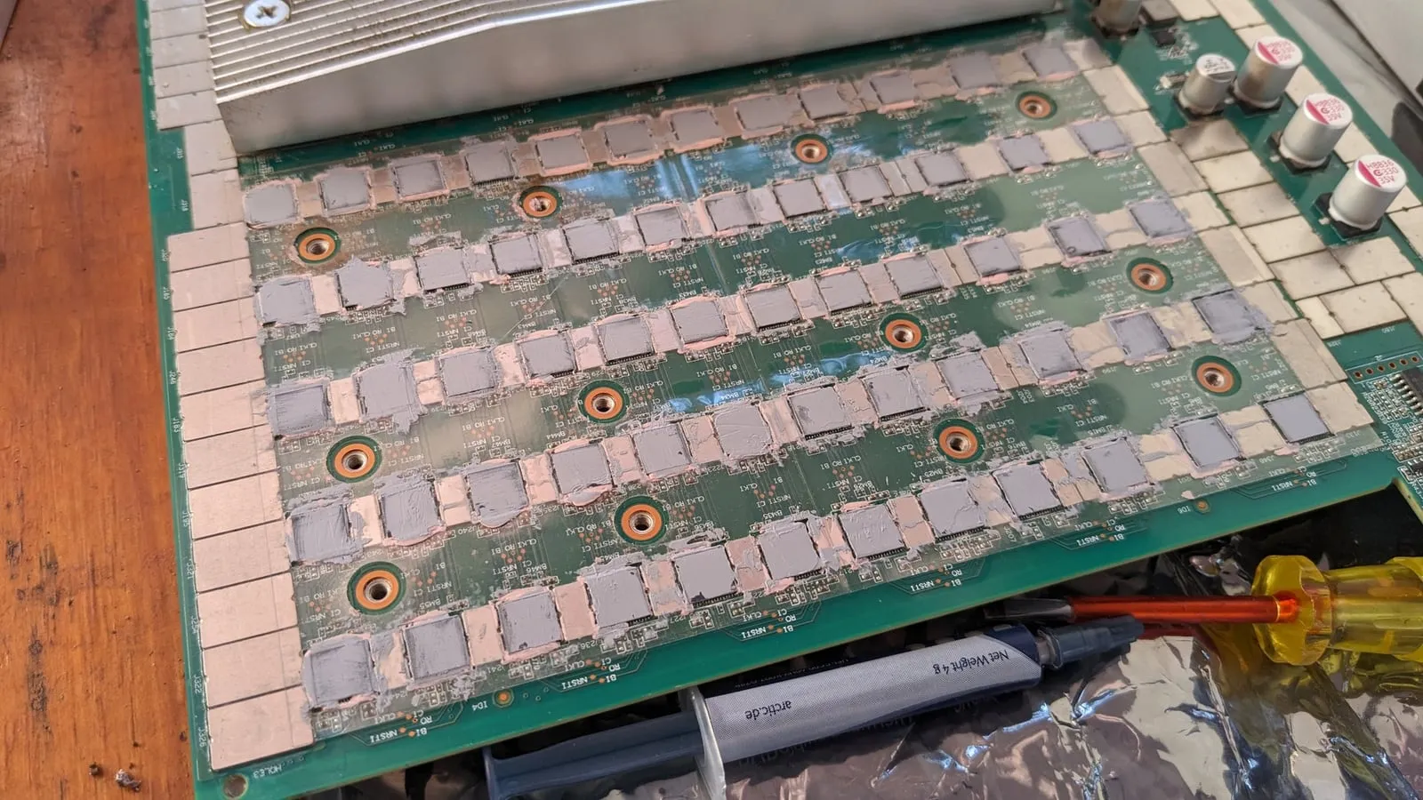 Rows of ASIC chips on a hash board with fresh thermal paste applied